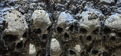 A scenic surface with skull forms embedded in rough texture.